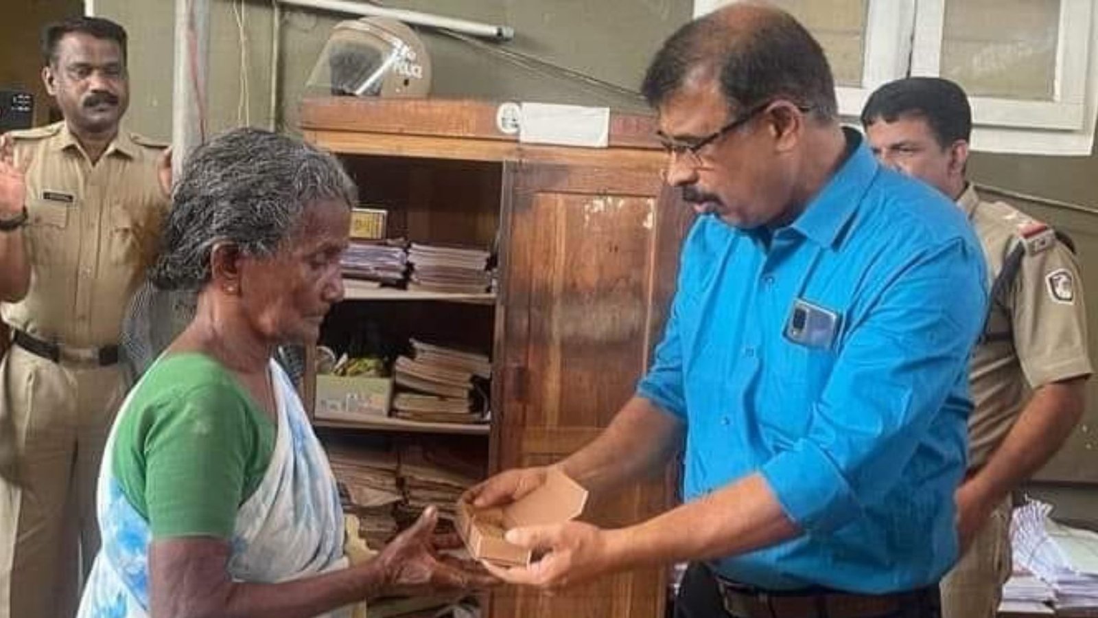 Govind Prasad handing over the new gold chain to the woman at Ottapalam Police Station on his retirement day.