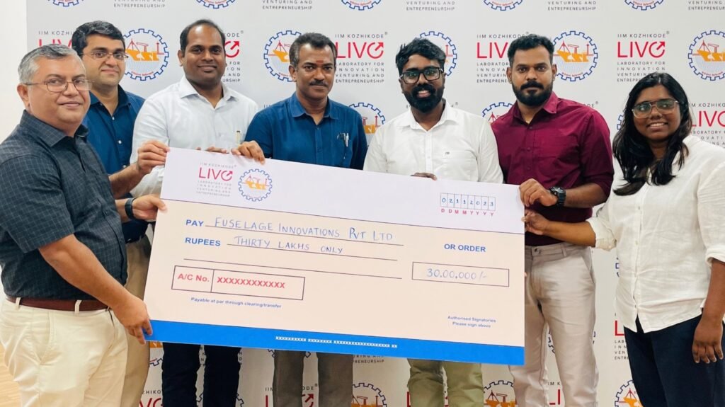 Officials of IIMK Live and Cochin Shipyard Limited handing over the grant of Rs 30 lakh to Devan Chandrasekharan and Devika Chandrasekaran of Fuselage Innovations.